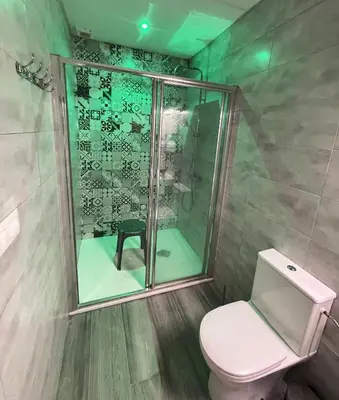 a bathroom with a toilet and a glass shower at Apartamento Plaza del Cabildo - Sanlúcar Centro in Sanlúcar de Barrameda