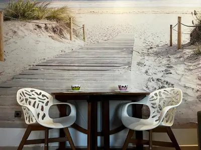 a wooden path to the beach with two chairs at El patio de la Pepa Grupo Ac Gestion in Cádiz