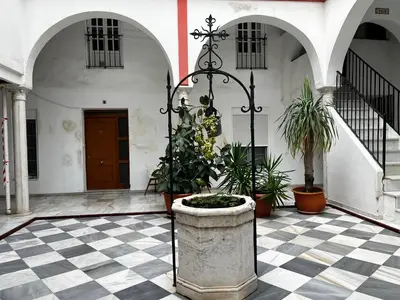 a courtyard with a stone planter with plants in it at El patio de la Pepa Grupo Ac Gestion in Cádiz