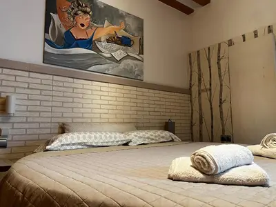 a bedroom with a bed with a painting on the wall at El patio de la Pepa Grupo Ac Gestion in Cádiz