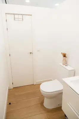 a white bathroom with a toilet and a sink at Urban Vistahermosa in El Puerto de Santa María