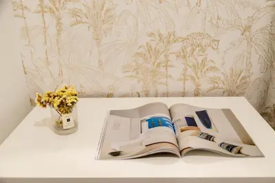 an open book on a table with a vase of flowers at Urban Vistahermosa in El Puerto de Santa María