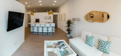a living room with a white couch and a mirror at Urban Vistahermosa in El Puerto de Santa María