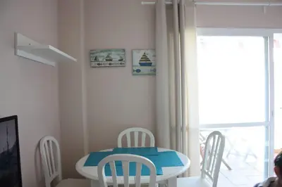 a table and chairs in a room with a window at Apartamento Costa Ballena Playa y Golf in Cádiz