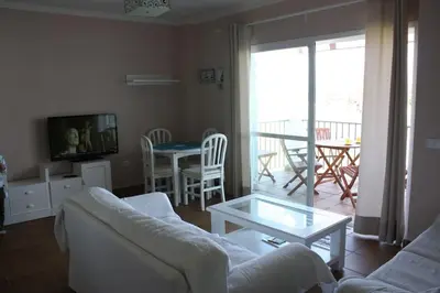 a living room with a white couch and a table at Apartamento Costa Ballena Playa y Golf in Cádiz