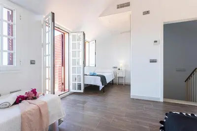 a white room with two beds and a mirror at 