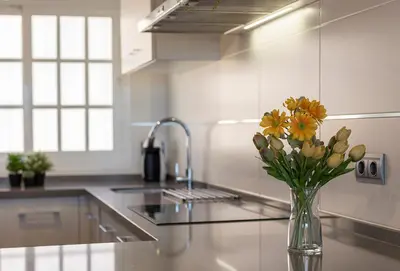 a vase of flowers sitting on a counter in a kitchen at 
