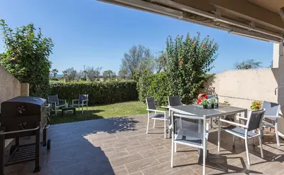 a patio with a table and chairs and a grill at 