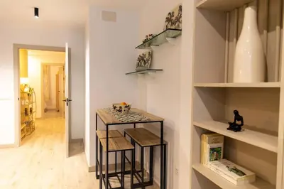 a kitchen with a counter and stools in a room at Arenas de la Victoria by Gades Gestión in Cádiz