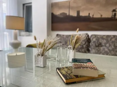 a glass table with a book and glasses on it at Arenas de la Victoria by Gades Gestión in Cádiz