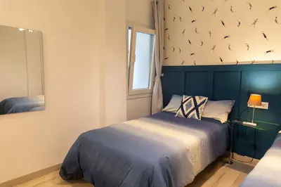 a bedroom with a bed with birds on the wall at Arenas de la Victoria by Gades Gestión in Cádiz