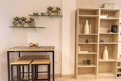 a kitchen with a table and some shelves at Arenas de la Victoria by Gades Gestión in Cádiz