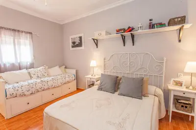 a bedroom with two beds and two lamps on the wall at Apartamento Centro Jerez Carbón in Jerez de la Frontera