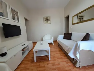 a white bedroom with a bed and a tv at Apartamento Centro Jerez Carbón in Jerez de la Frontera