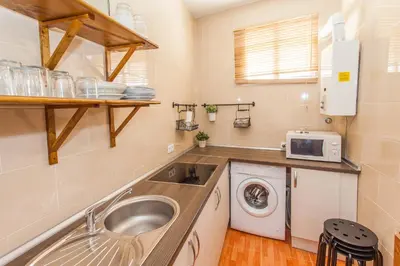 a small kitchen with a sink and a washing machine at Apartamento Centro Jerez Carbón in Jerez de la Frontera