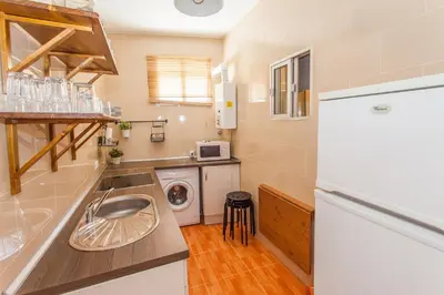 a small kitchen with a sink and a washing machine at Apartamento Centro Jerez Carbón in Jerez de la Frontera