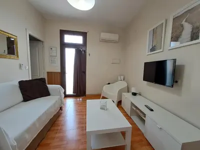 a living room with a white couch and a tv at Apartamento Centro Jerez Carbón in Jerez de la Frontera