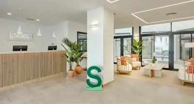 a lobby with a s sign in the middle of it at Sercotel Cruz Del Mar in Chipiona