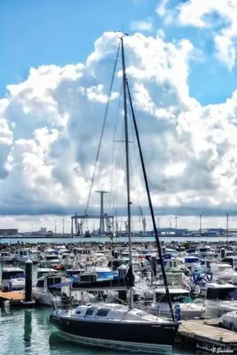 a sailboat is docked in a harbor with other boats at A 5 min de la playa Victoria y del Htal Pta Mar in Cádiz