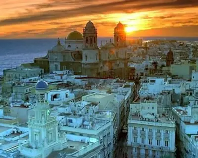 a view of a city at sunset at A 5 min de la playa Victoria y del Htal Pta Mar in Cádiz