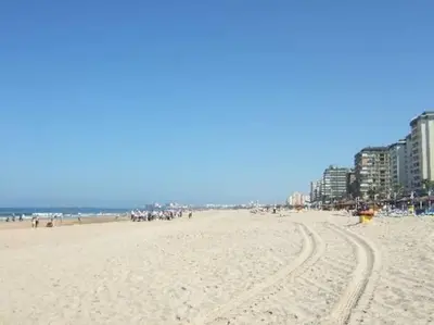a beach with a lot of people and buildings at A 5 min de la playa Victoria y del Htal Pta Mar in Cádiz