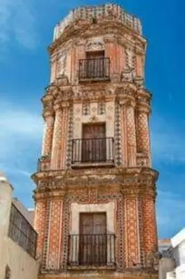 a tall tower with a clock on top of it at A 5 min de la playa Victoria y del Htal Pta Mar in Cádiz
