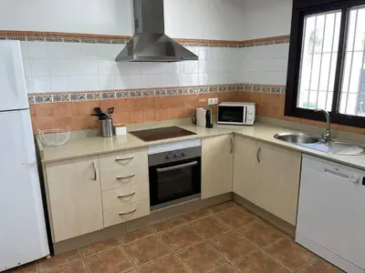 a kitchen with a sink and a stove top oven at La Casita de Nora in Conil de la Frontera