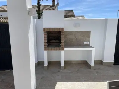 a building with a fireplace on a patio at La Casita de Nora in Conil de la Frontera