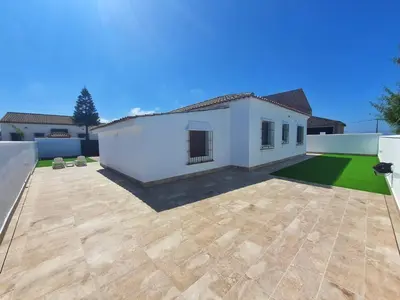 a large white house with a large yard at La Casita de Nora in Conil de la Frontera