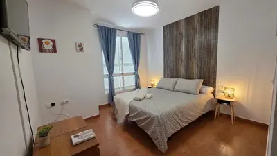 a bedroom with a bed and a large window at El Baluarte by Sanlúcar Housing in Sanlúcar de Barrameda