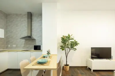 a kitchen and dining room with a table and a tv at Antiguo Balneario in Cádiz