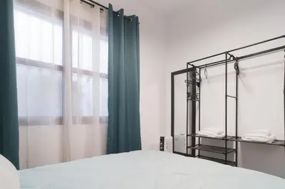 a bedroom with a bed and a green curtain at El Rincón de Pepa y Juan in Jerez de la Frontera