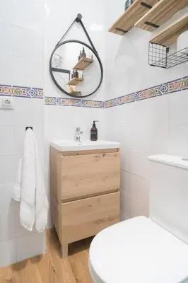 a bathroom with a white toilet and a mirror at El Rincón de Pepa y Juan in Jerez de la Frontera