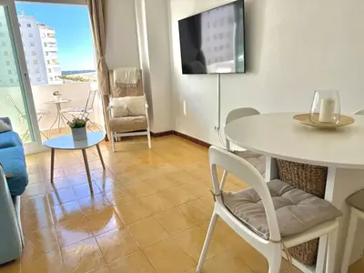 a living room with a table and a tv at Vistas al mar primera linea playa Valdelagrana in El Puerto de Santa María