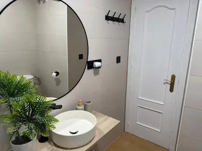 a bathroom with a white sink and a mirror at Vistas al mar primera linea playa Valdelagrana in El Puerto de Santa María