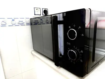 a microwave oven sitting on a counter in a kitchen at Vistas al mar primera linea playa Valdelagrana in El Puerto de Santa María