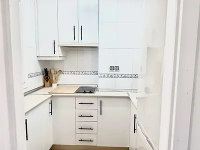 a white kitchen with white cabinets and a counter at Vistas al mar primera linea playa Valdelagrana in El Puerto de Santa María