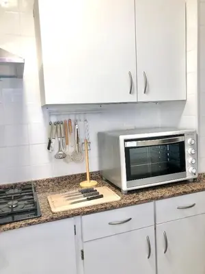 a kitchen with white cabinets and a microwave on a counter at ALOJA Diseño acogedor 3 habitaciones in El Puerto de Santa María