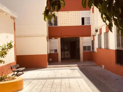 a building with a door and a bench in a courtyard at ALOJA Diseño acogedor 3 habitaciones in El Puerto de Santa María