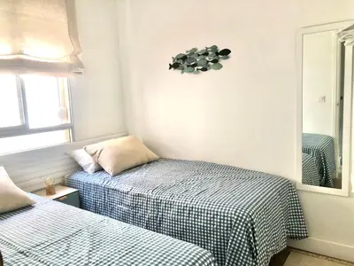 a bedroom with two beds and a mirror at ALOJA Diseño acogedor 3 habitaciones in El Puerto de Santa María
