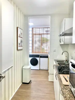 a white kitchen with a counter and a window at ALOJA Diseño acogedor 3 habitaciones in El Puerto de Santa María