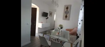 a white living room with a glass table and chairs at Apartamento Eluan in Arcos de la Frontera