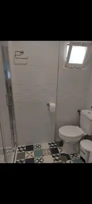 a bathroom with a toilet and a tile floor at Apartamento Eluan in Arcos de la Frontera