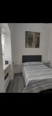 a bedroom with a bed and a picture on the wall at Apartamento Eluan in Arcos de la Frontera