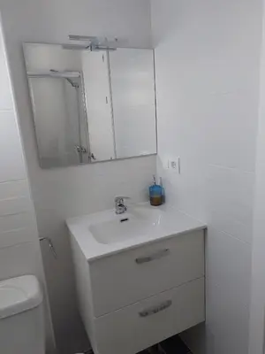 a white bathroom with a sink and a mirror at Apartamento Eluan in Arcos de la Frontera