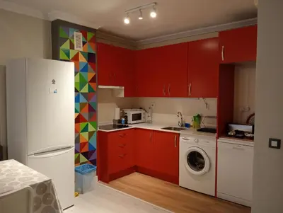 a kitchen with red cabinets and a white refrigerator at Apartamento Buhaira Free Parking in Cádiz