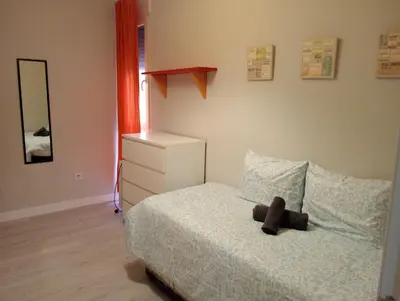 a bedroom with a bed with a dresser and a mirror at Apartamento Buhaira Free Parking in Cádiz