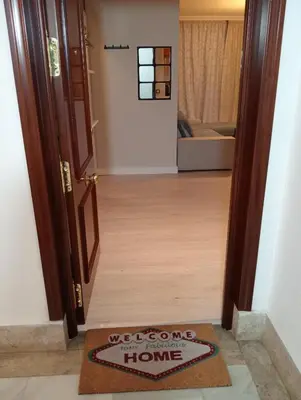 a door to a home with a welcome mat on the floor at Apartamento Buhaira Free Parking in Cádiz