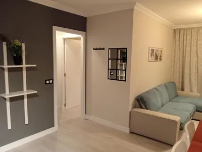 a living room with a blue couch and a door at Apartamento Buhaira Free Parking in Cádiz