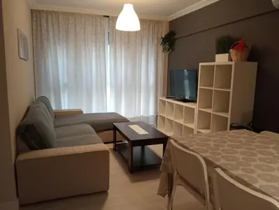 a small living room with a couch and a tv at Apartamento Buhaira Free Parking in Cádiz